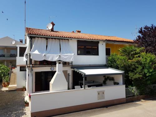a white building with a white umbrella on it at Apartment Auretta in Novigrad Istria