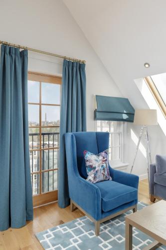 una sedia blu in un soggiorno con finestra di Destiny Scotland - Royal Mile Residence a Edimburgo