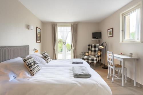 ボニューにあるLes Terrasses du Luberonのベッド2台と机と椅子のある寝室