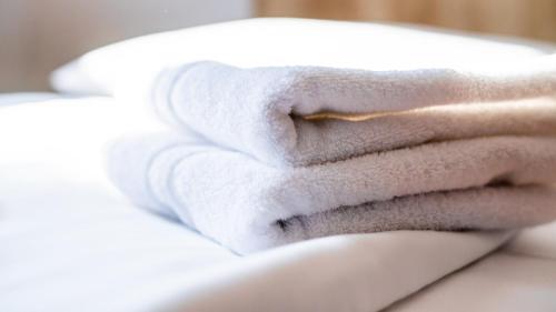 a stack of towels sitting on top of a bed at Hotel Kreuz in Schwäbisch Gmünd