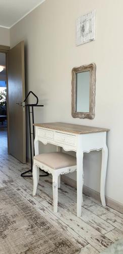 a white desk with a mirror and a stool at Family Apartment Nida in Nida