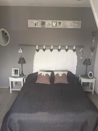 une chambre avec un grand lit avec deux oreillers dans l'établissement Cosy maison 3 chambres Honfleur jardin, parking privé et jacuzzi, à Honfleur