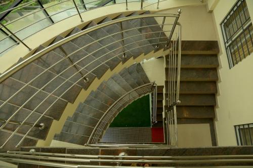 a spiral staircase in a building with a stair case at Woodside residency in Thekkady