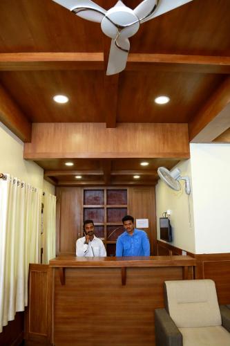 two men are standing in a room at Woodside residency in Thekkady