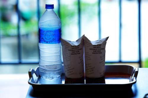 a tray with a bottle of water and a drink at Woodside residency in Thekkady