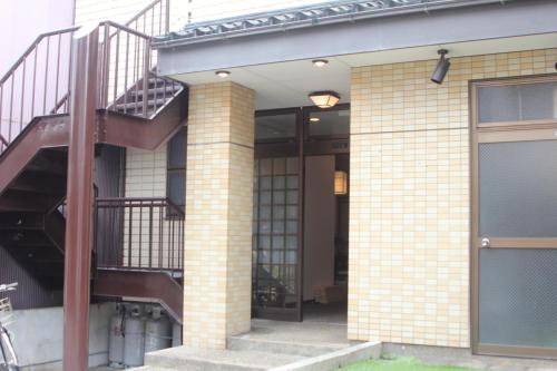 - un bâtiment en briques avec un escalier et une porte dans l'établissement Shaq Bighouse, à Kanazawa
