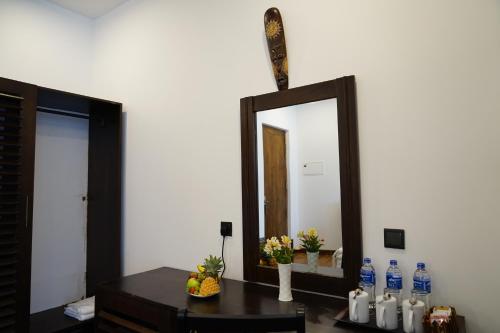 a mirror on a wall next to a table with bottles of water at The Ramp in Nuwara Eliya