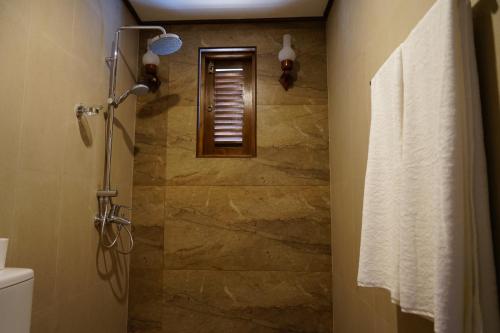 a bathroom with a walk in shower with a window at The Ramp in Nuwara Eliya