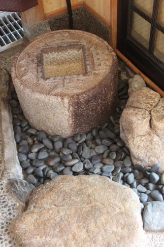 a stone tub sitting on top of a pile of rocks at Shaq Bighouse in Kanazawa