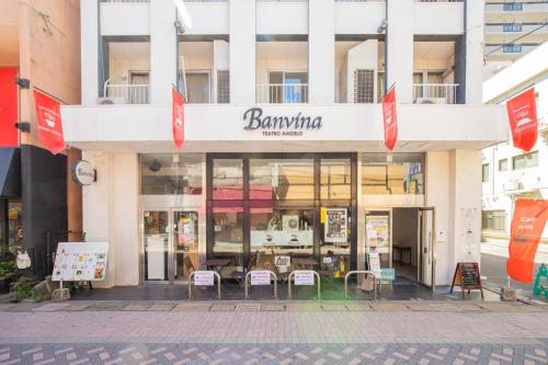 a store front of a building with tables and chairs at Guesthouse Banvina in Kagoshima