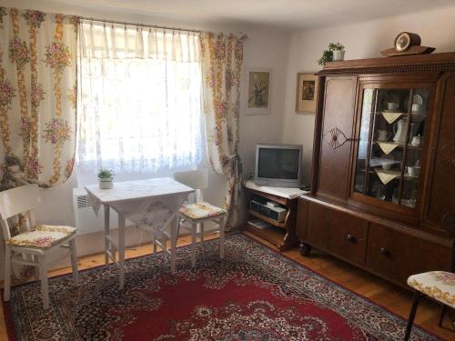 Zimmer mit einem Tisch, einem TV und einem Fenster in der Unterkunft Privát U Čejků in Telč