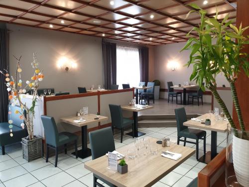 a restaurant with tables and chairs in a room at Hôtel Malpel in Decazeville