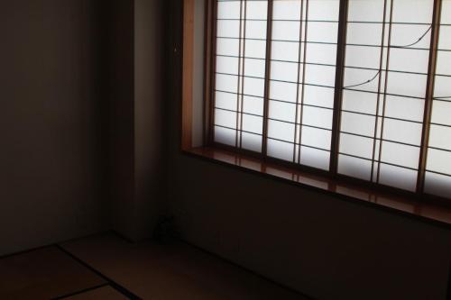 an empty room with a window with sunlight coming in at Shaq Bighouse in Kanazawa