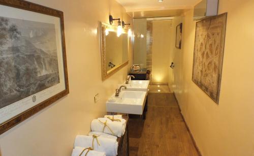 a bathroom with two sinks and a mirror and towels at Residenze Gregoriane - Residenza d'Epoca in Tivoli