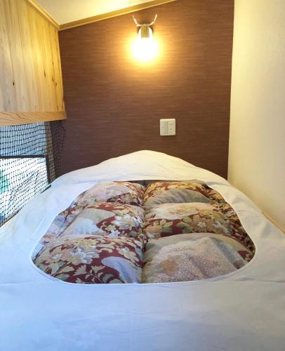 a bed in a bedroom with a bedspread on it at Stay Nikko Guesthouse in Nikko