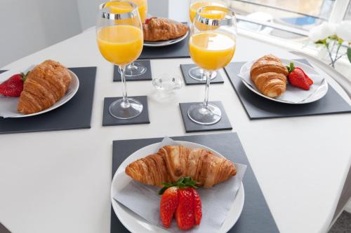 a table with plates of croissants and strawberries and glasses of orange juice at amazing apartments - Annandale St near The Playhouse - Free Parking in Edinburgh