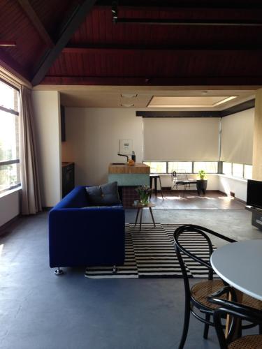 a living room with a blue couch and a table at Het Lokaal in Middelburg