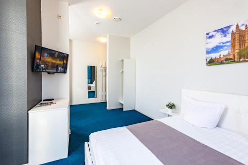 a hotel room with a bed and a flat screen tv at Hotel England Tyumen Center in Tyumen