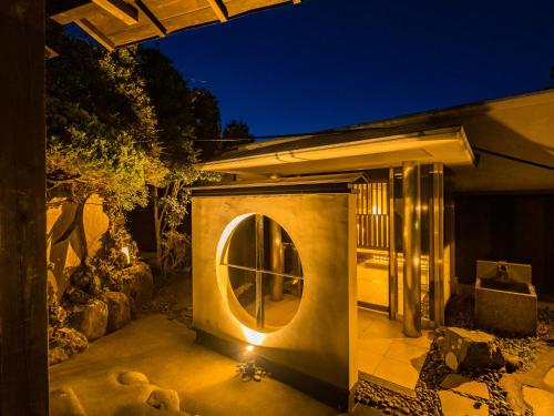 a small house with a round window on a patio at Nagominoyado Hanagokoro - Reopening in Mar 2024 in Hakone