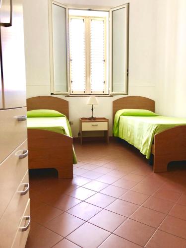 a bedroom with two beds and a mirror in it at Appartamenti Sul Mare in Avola