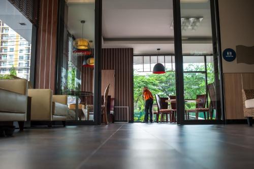 a person standing in a lobby looking out the door at Marsi Hotel Bangkok in Bangkok