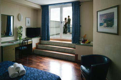 a hotel room with a staircase with people walking out the window at Hotel Royal in Fermo