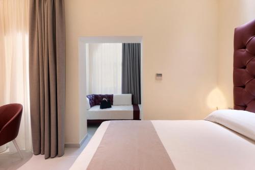 a hotel room with a bed and a chair at Palazzo Tritone & Abagnale in Sorrento