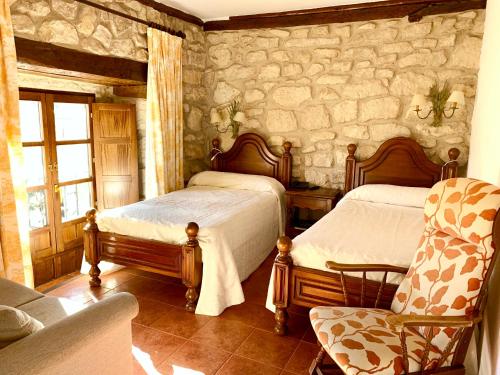 a bedroom with a bed and a dresser at Hotel Tres Coronas de Silos in Santo Domingo de Silos