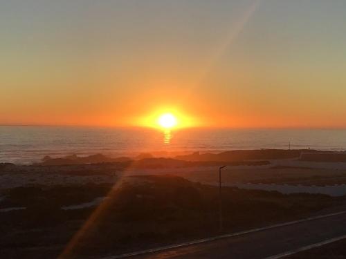 a sunset over the ocean with the sun in the sky at Chez James in Yzerfontein