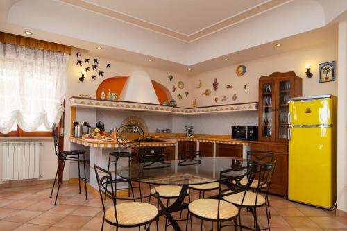 uma cozinha com uma mesa e cadeiras e um frigorífico amarelo em Domus Amalfi Coast em Maiori