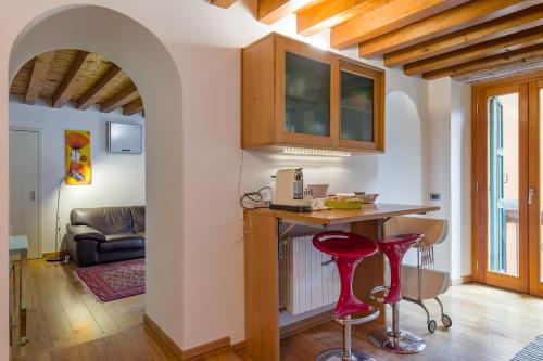 a kitchen with a table and two red stools at Downtown Apartment Verona in Verona