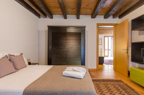 a bedroom with a large bed and a television at Downtown Apartment Verona in Verona