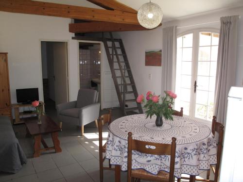 a living room with a table with a vase of flowers on it at Résidence Miro, gîtes climatisés avec piscine et tennis in Les Arcs sur Argens