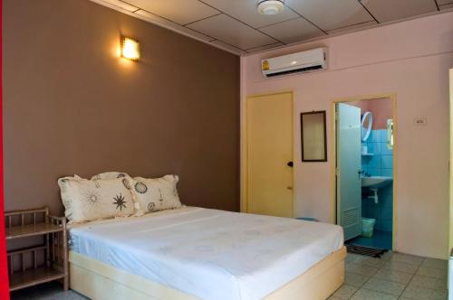 1 dormitorio con cama y puerta amarilla en The Lost Resort, en Ko Samed