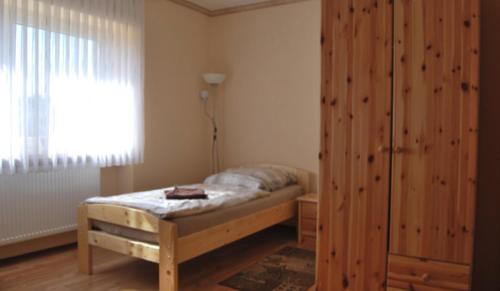 a bedroom with a bed and a large wooden cabinet at Ferienappartement Pirmasens in Pirmasens