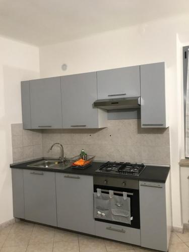 a kitchen with white cabinets and a stove and sink at Casamina in Bellinzago Lombardo