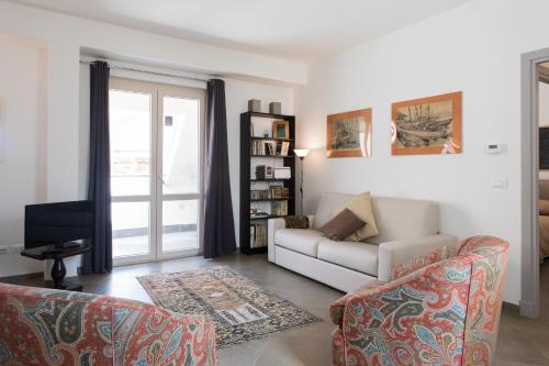 a living room with a couch and a tv at Overseas - Penthouse - Attico - Palazzo San Matteo - Palermo in Palermo