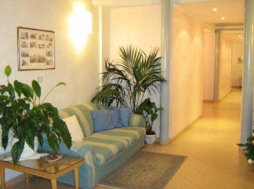 a living room with a couch and potted plants at Hotel Castello in Mesagne