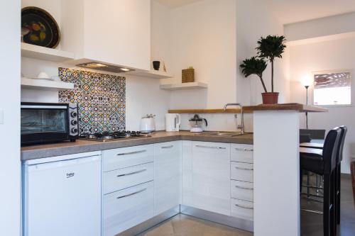 eine Küche mit weißen Schränken und einer Mikrowelle in der Unterkunft Overseas - Appartamento Attico - Palazzo San Matteo in Palermo