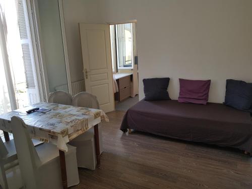 une pièce avec une table et un lit et une table et des chaises dans l'établissement 18 rue des petits fossés - 5, à Lourdes