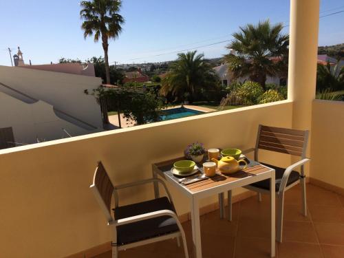 a table and chairs on a balcony with a view at VILLA EBER - independent 1 & 2 bedroom apartments, pool, air con, fast Wi-Fi, near old town of Albufeira and beaches in Albufeira