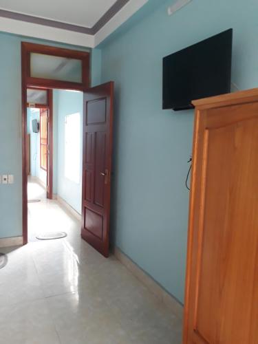 a hallway with a television on a blue wall at Nguyên căn Homestay 4 phòng ngủ sát biển in Sầm Sơn