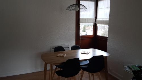 une table à manger avec des chaises et une fenêtre dans l'établissement Kiruna, à Le Mont-Dore
