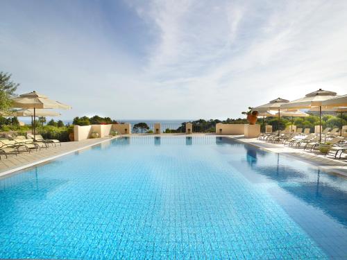 a large swimming pool with chairs and umbrellas at Hapimag Resort Cefalù in Cefalù
