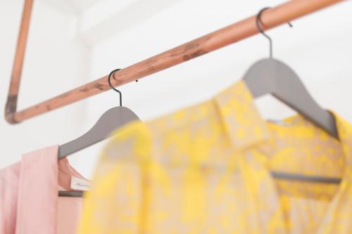 a rack of yellow shirts hanging on a rail at Skyros Ammos Hotel in Skiros
