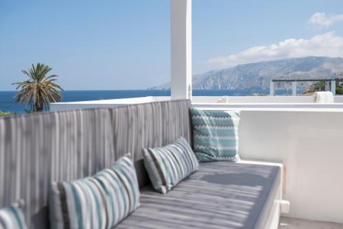 a couch on a balcony with a view of the ocean at Skyros Ammos Hotel in Skiros