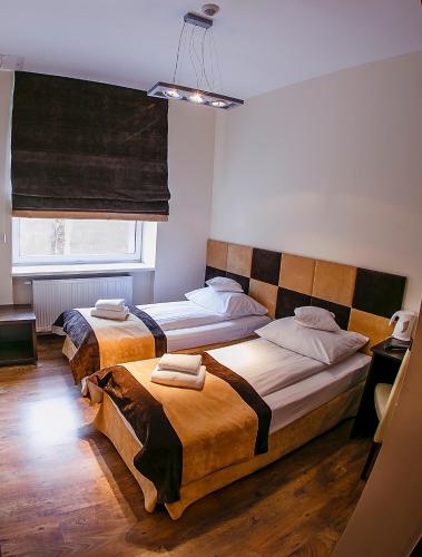 a bedroom with two beds and a window at Boutique Hotel's II Rewolucji in Łódź