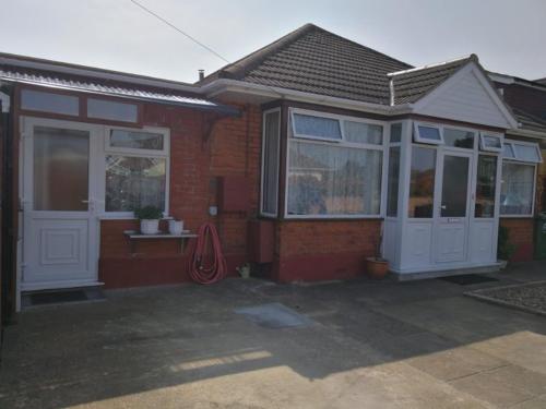 a house with two white doors at Rest room near to Heathrow Airport in Ashford