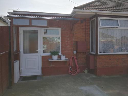a red brick house with a white door and a window at Rest room near to Heathrow Airport in Ashford