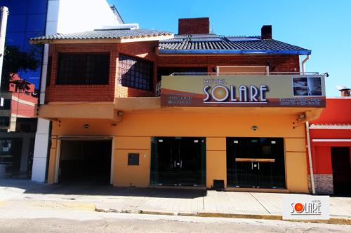 una tienda frente a un edificio con un cartel. en Hotel Solare, en Santana do Livramento